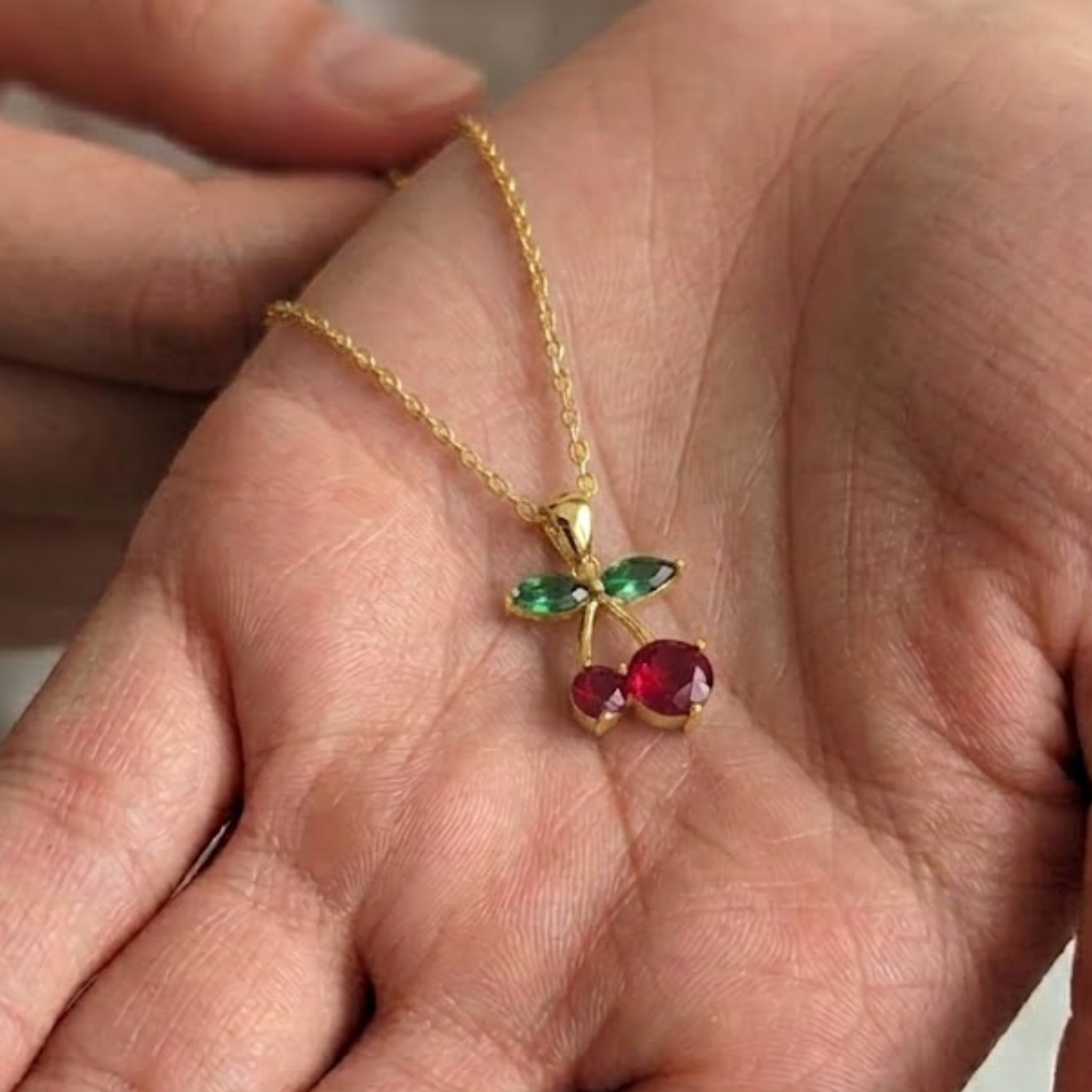 Elegant green diamond and red gemstone necklace crafted in polished rose gold.