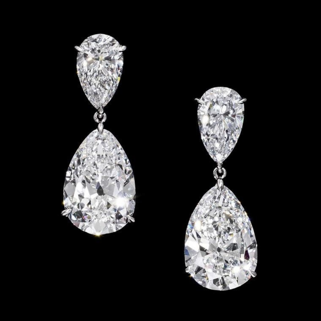 Pair of teardrop-shaped diamond earrings on a black background