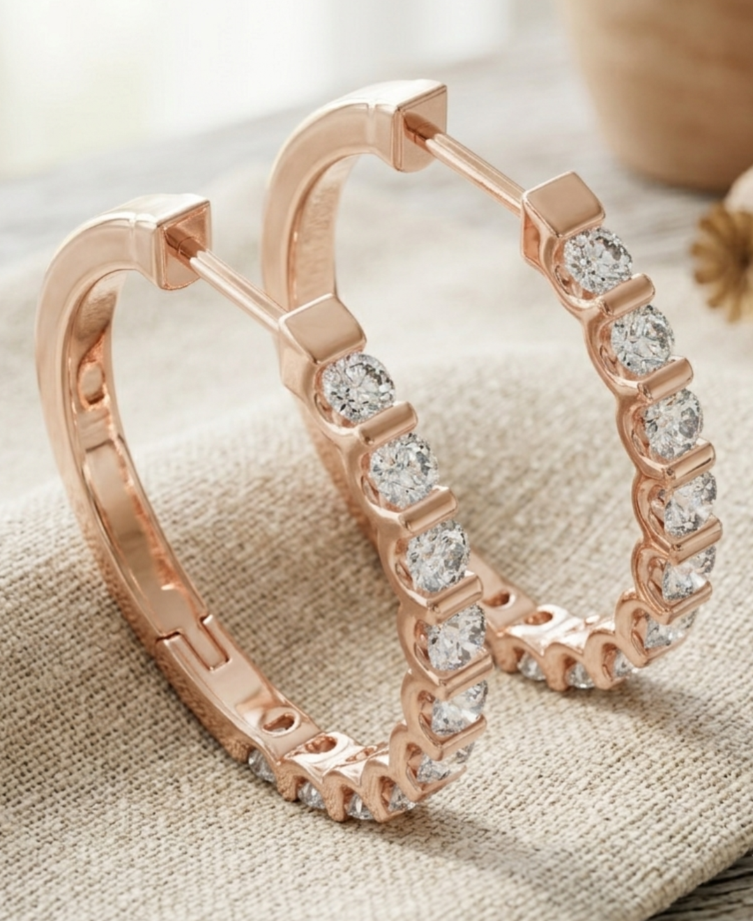 Close-up of 1.00 CTW lab-grown diamond hoop earrings with polished gold bar details between the stones.