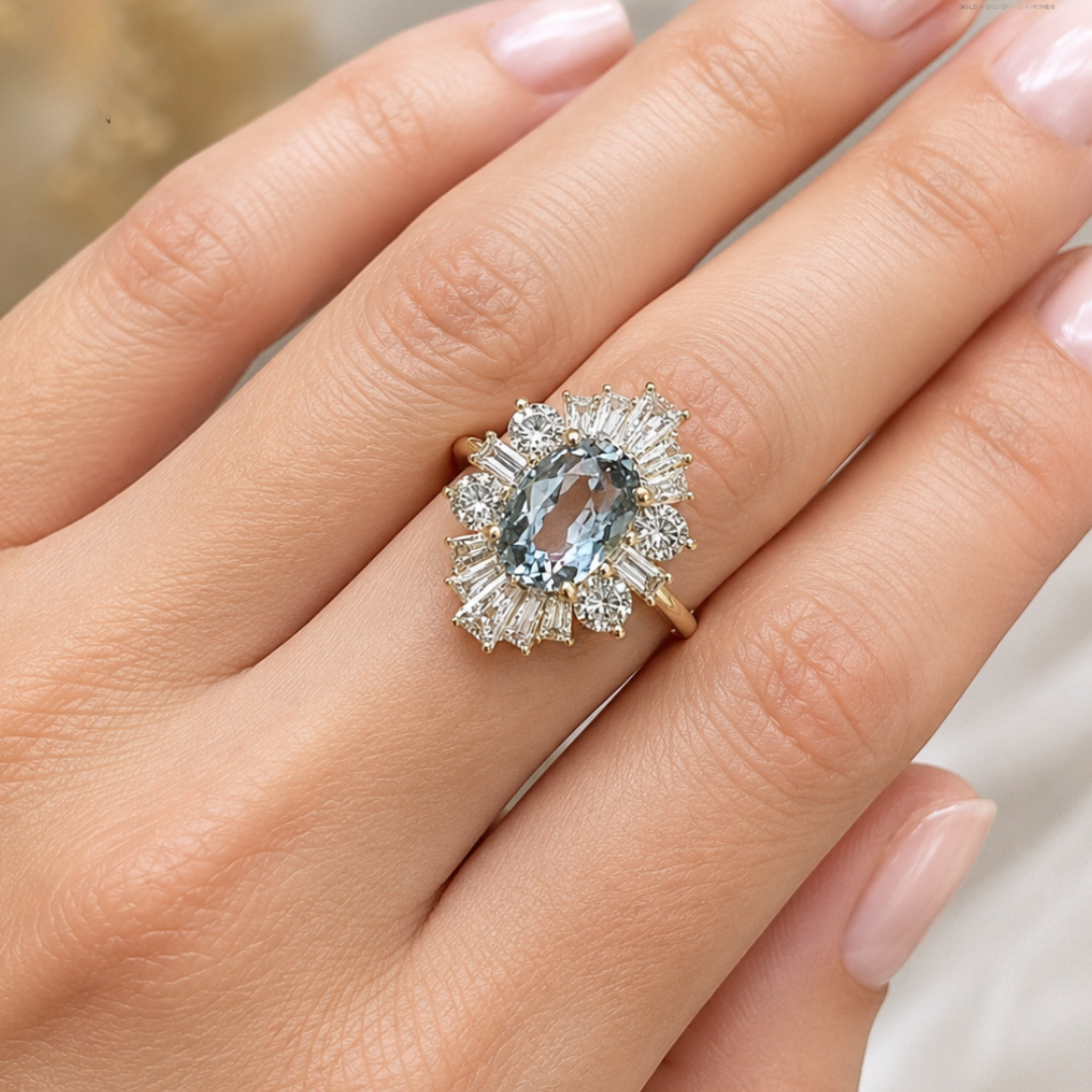 A close-up of a hand wearing a gold ring with a large oval light blue gemstone surrounded by a halo of clear baguette and round-cut stones.