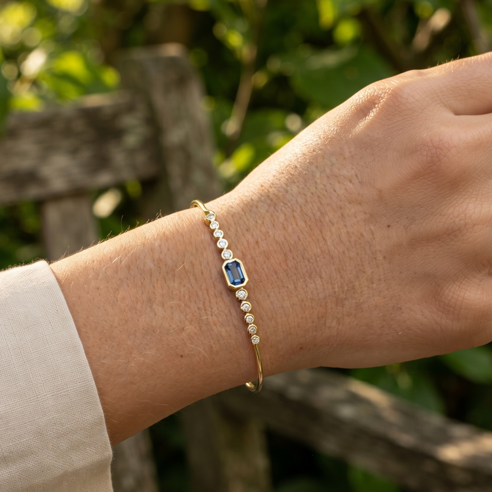 Kiashaa Jewellery 1.582 CTW blue emerald and round diamond bangle in polished yellow gold.
