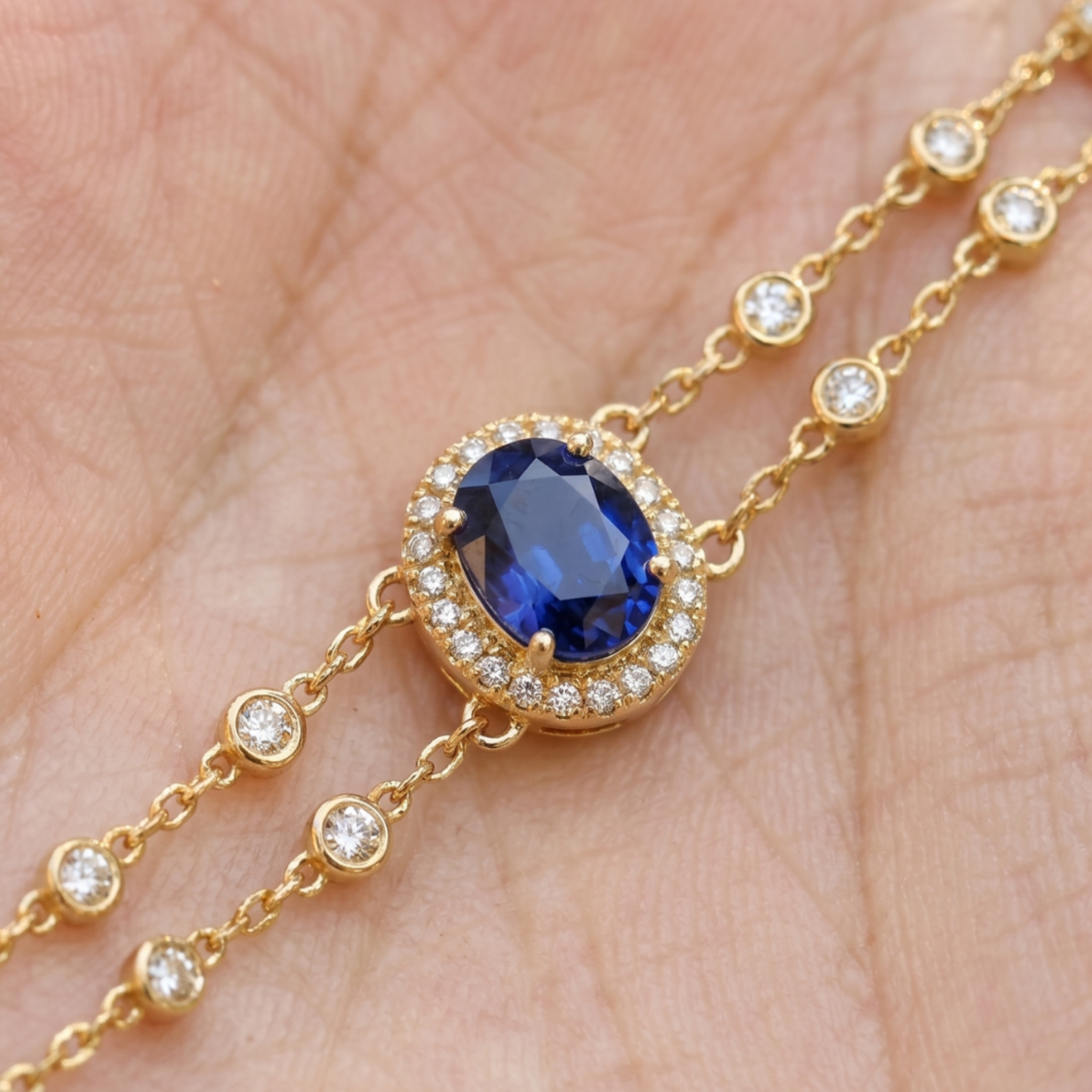 2 CT oval blue sapphire bracelet with diamond halo in yellow gold by Kiashaa Jewellery.