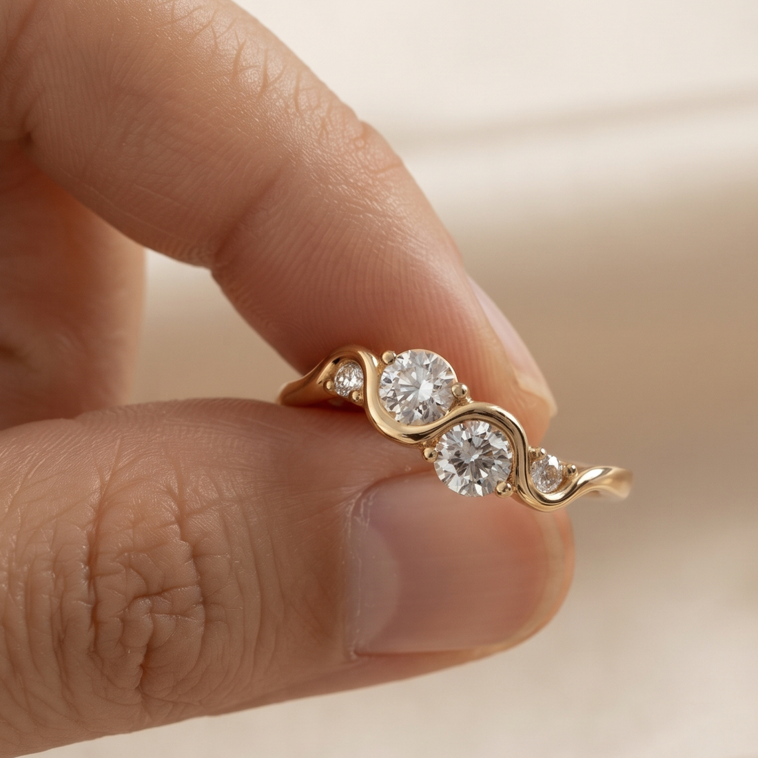 A gold ring with three round-cut clear gemstones set on a person's finger, shown in a close-up shot.