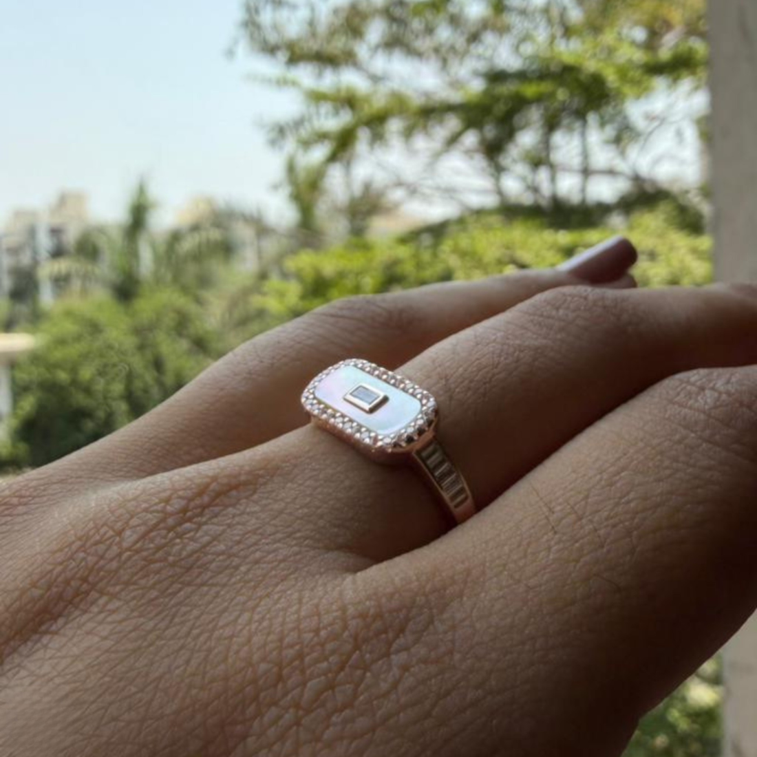 Geometric diamond ring featuring a luminous elongated mother-of-pearl center.