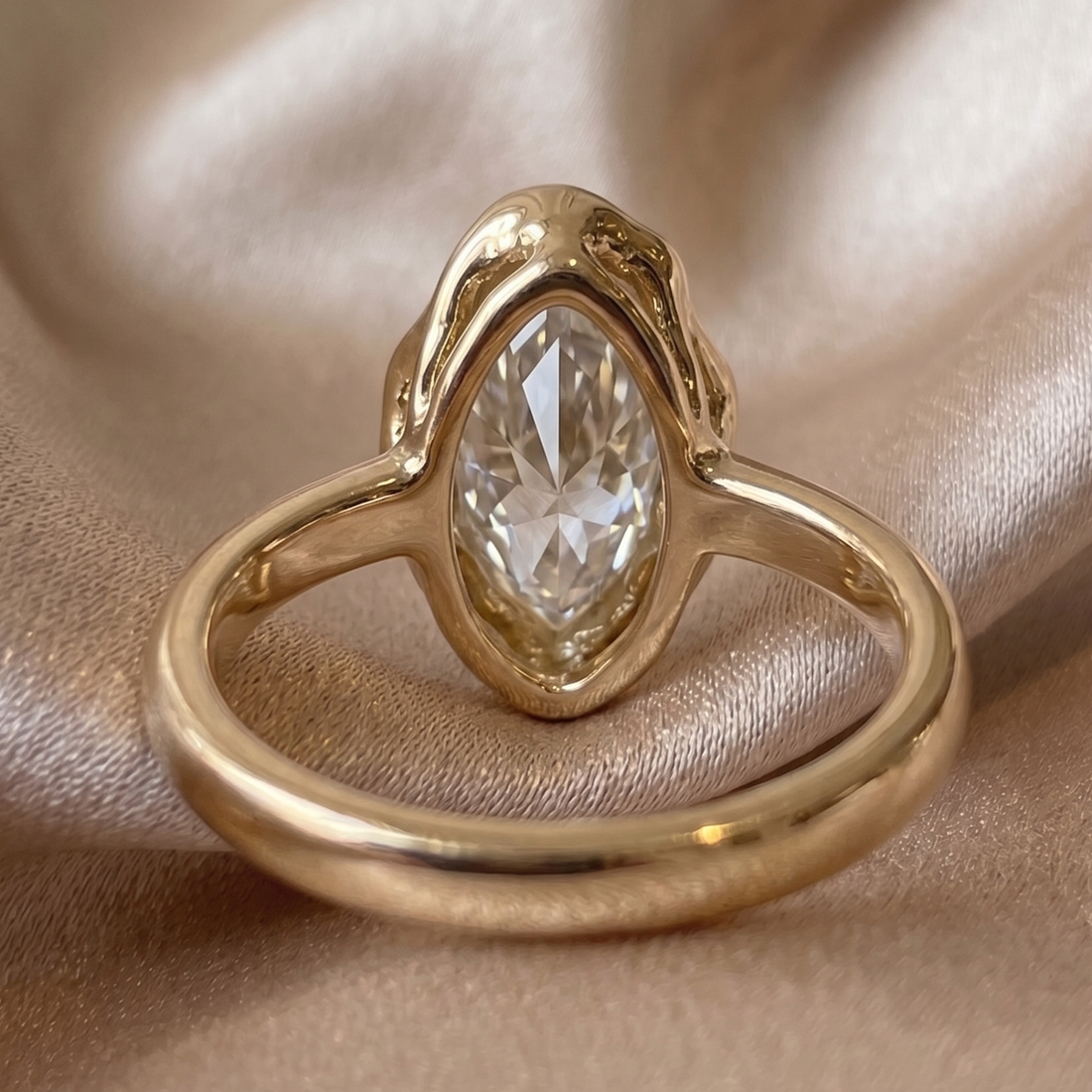 Modern marquise diamond proposal ring with sculptural gold frame