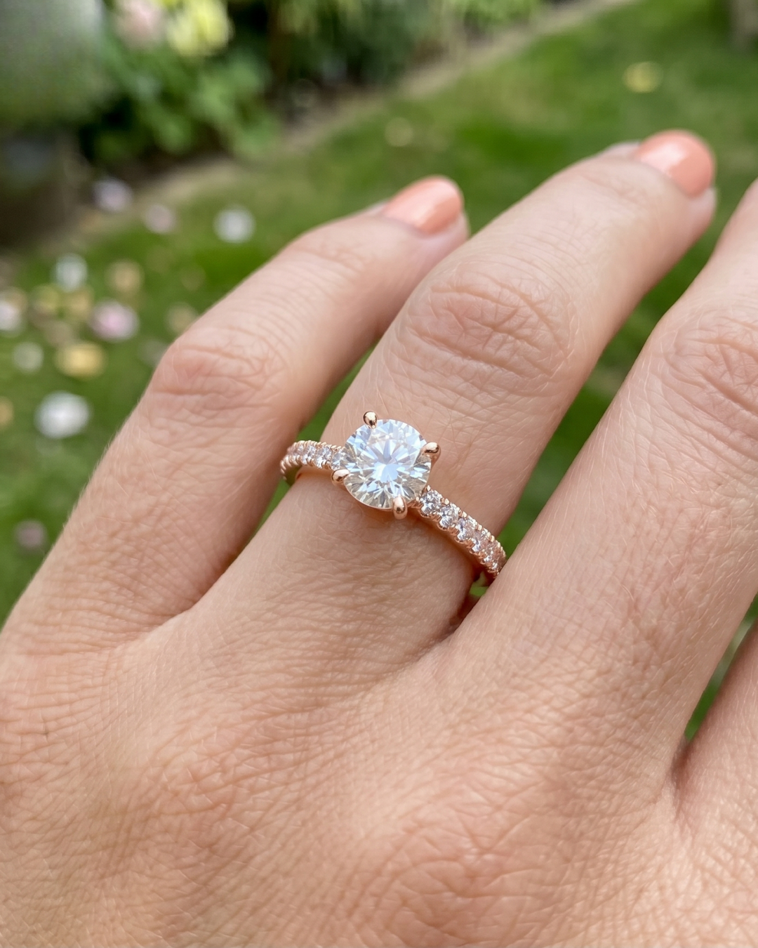 Close-up of a round lab-grown diamond ring by Kiashaa Jewellery with a polished rose gold band and side diamonds.