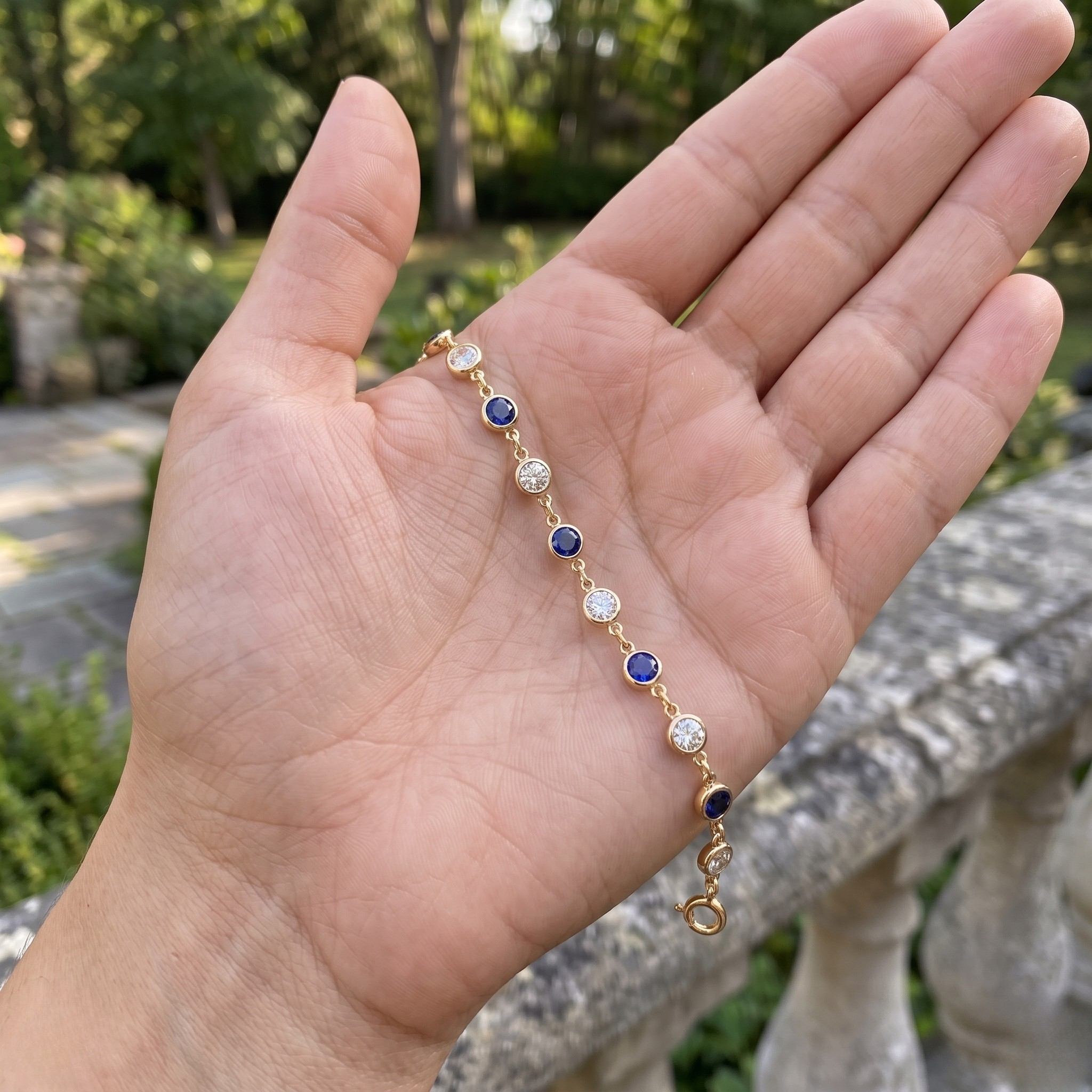 Luxury tennis bracelet with round blue gemstones and brilliant white diamonds.