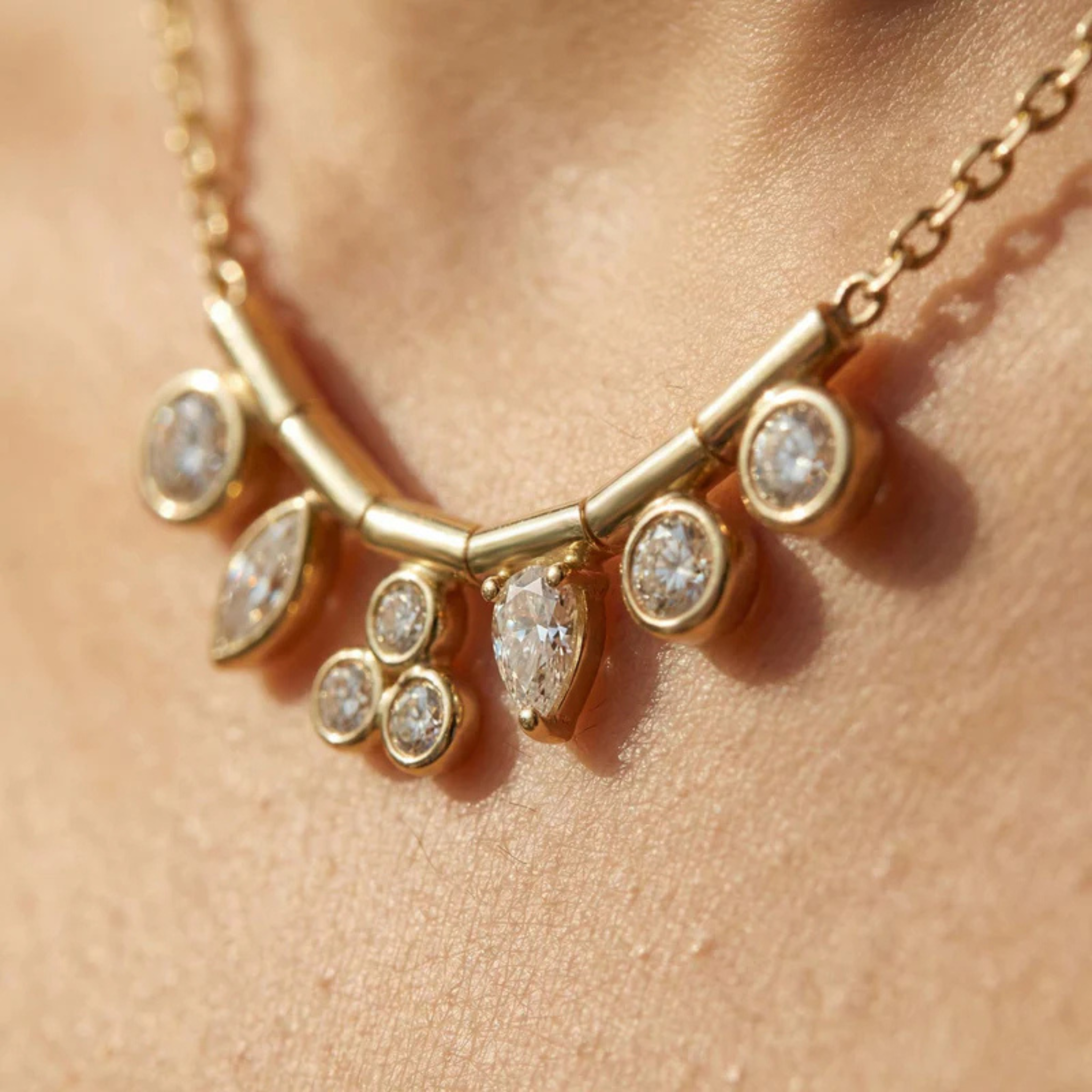 Gold necklace with diamond-like stones on a person's neck