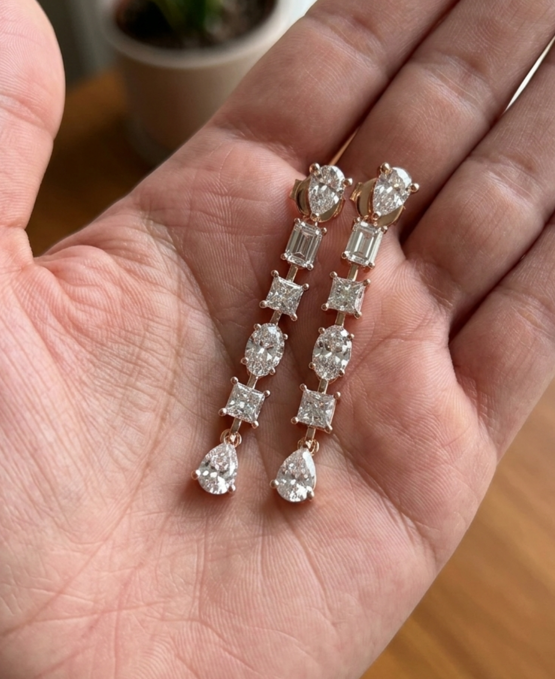 Hand-held view of 2.860 CTW multi-shape diamond earrings showing their elegant elongated proportions.