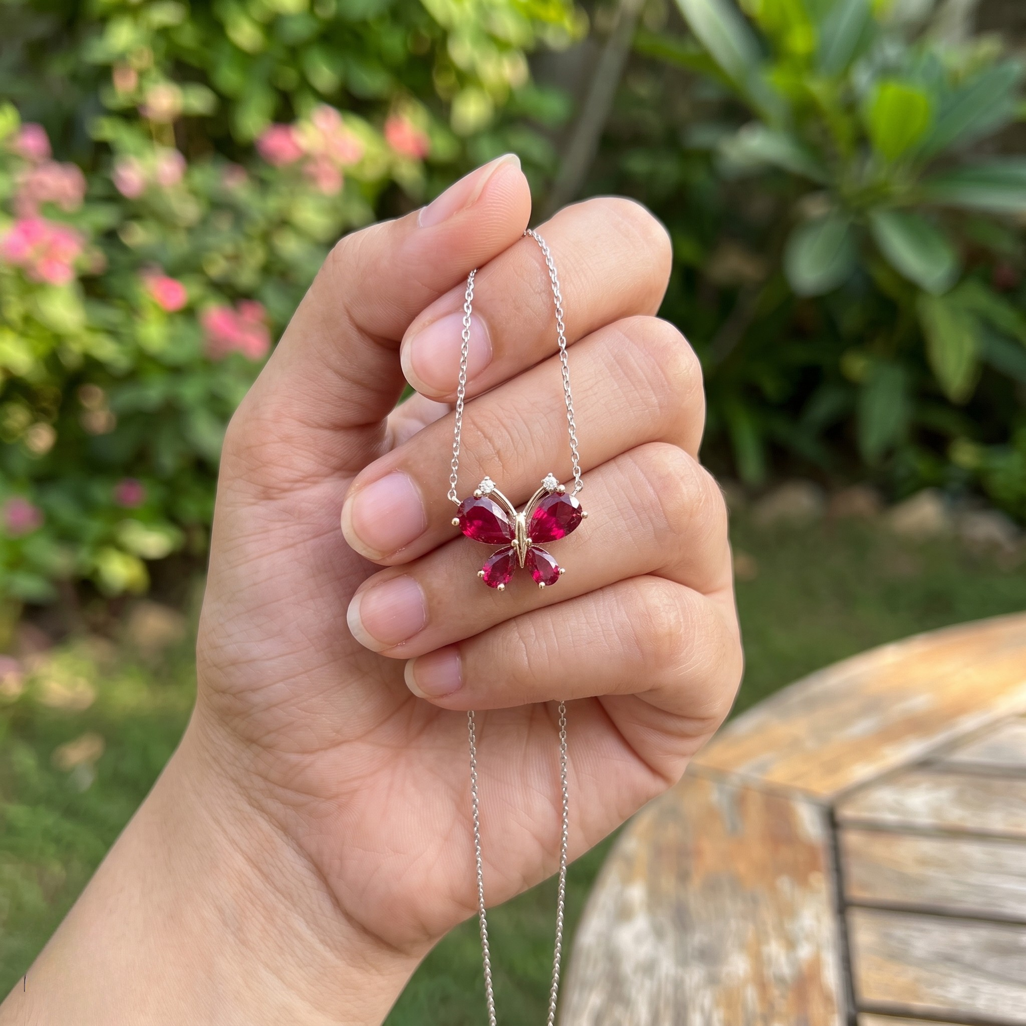 Red pear gemstone butterfly pendant necklace with lab-grown diamond accents by Kiashaa Jewellery.