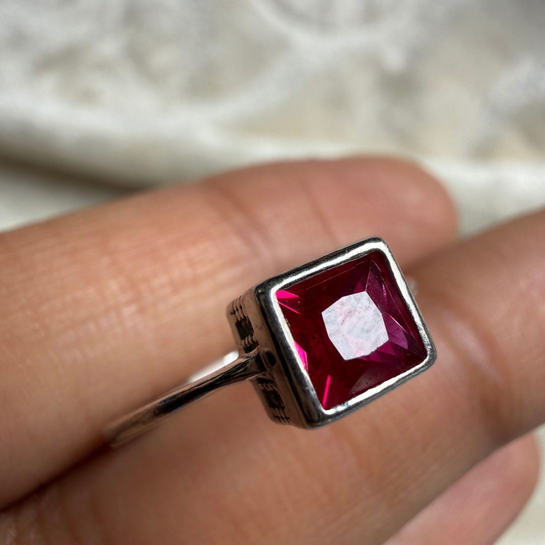 Red princess-cut gemstone solitaire ring in white gold by Kiashaa Jewellery.