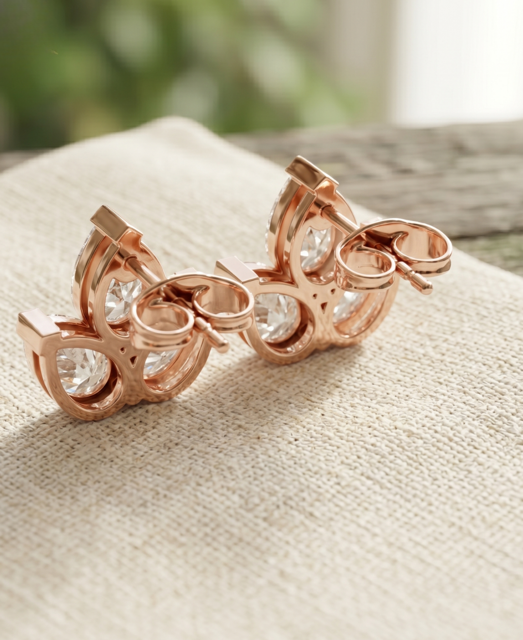 Close-up of pear lab-grown diamond earrings worn on ear in a refined stud design.