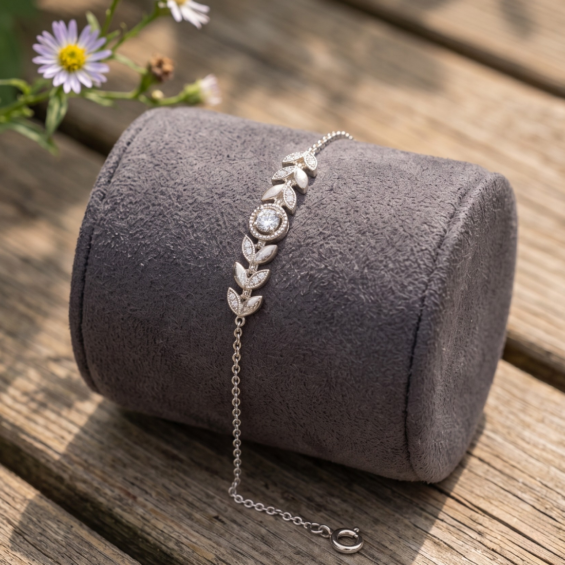 Botanical diamond bracelet featuring a 5.10 mm round center stone with leaf motifs.