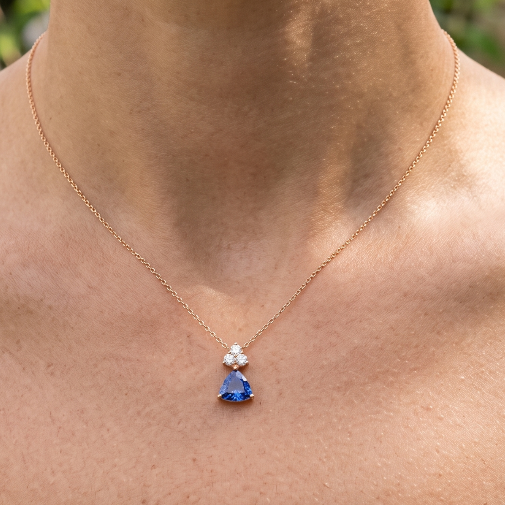 0.96 CTW blue trillion pendant necklace with a 6 mm center stone and three round diamond accents.