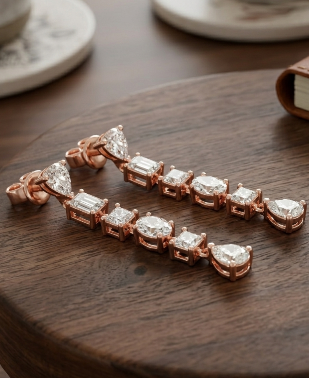 Side view of rose gold diamond drop earrings showing open basket galleries and individual prong settings.