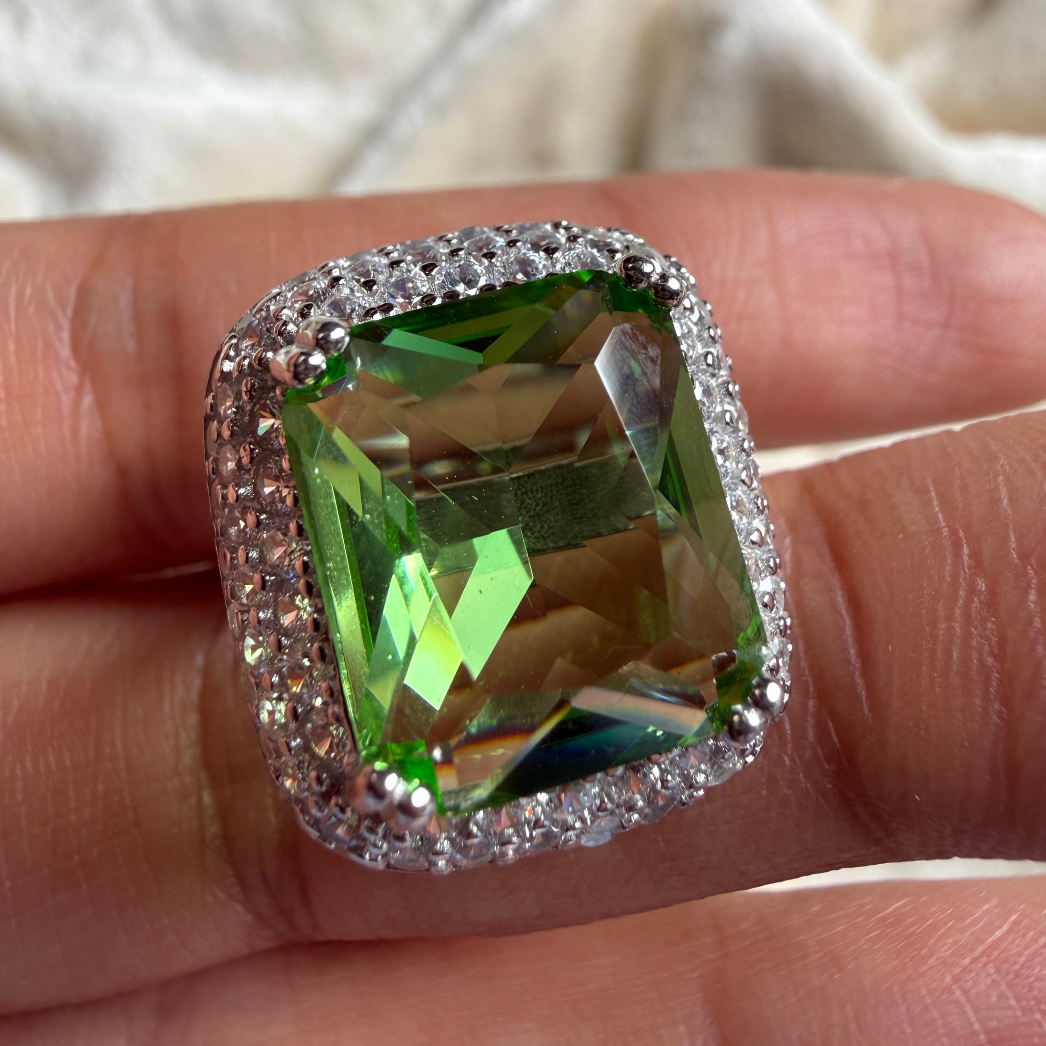 Green emerald-cut gemstone and lab-grown diamond double halo ring by Kiashaa Jewellery.