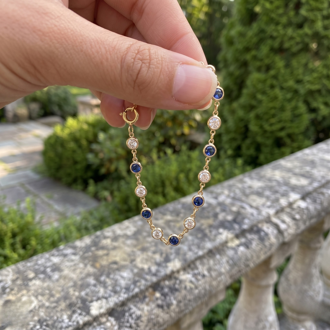 Luxury tennis bracelet with round blue gemstones and brilliant white diamonds.