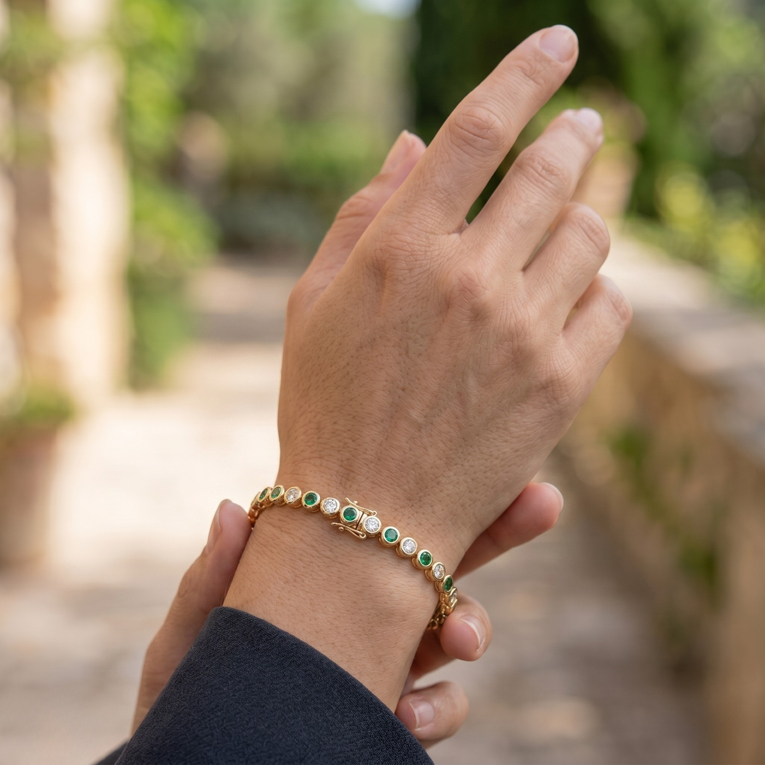 Alternating green gemstone and white diamond bracelet with round bezel-set stones.