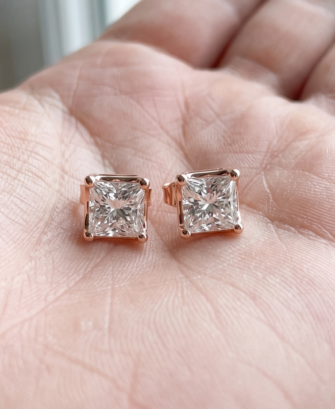 Ladies princess-cut diamond stud earrings with secure push-back closures.