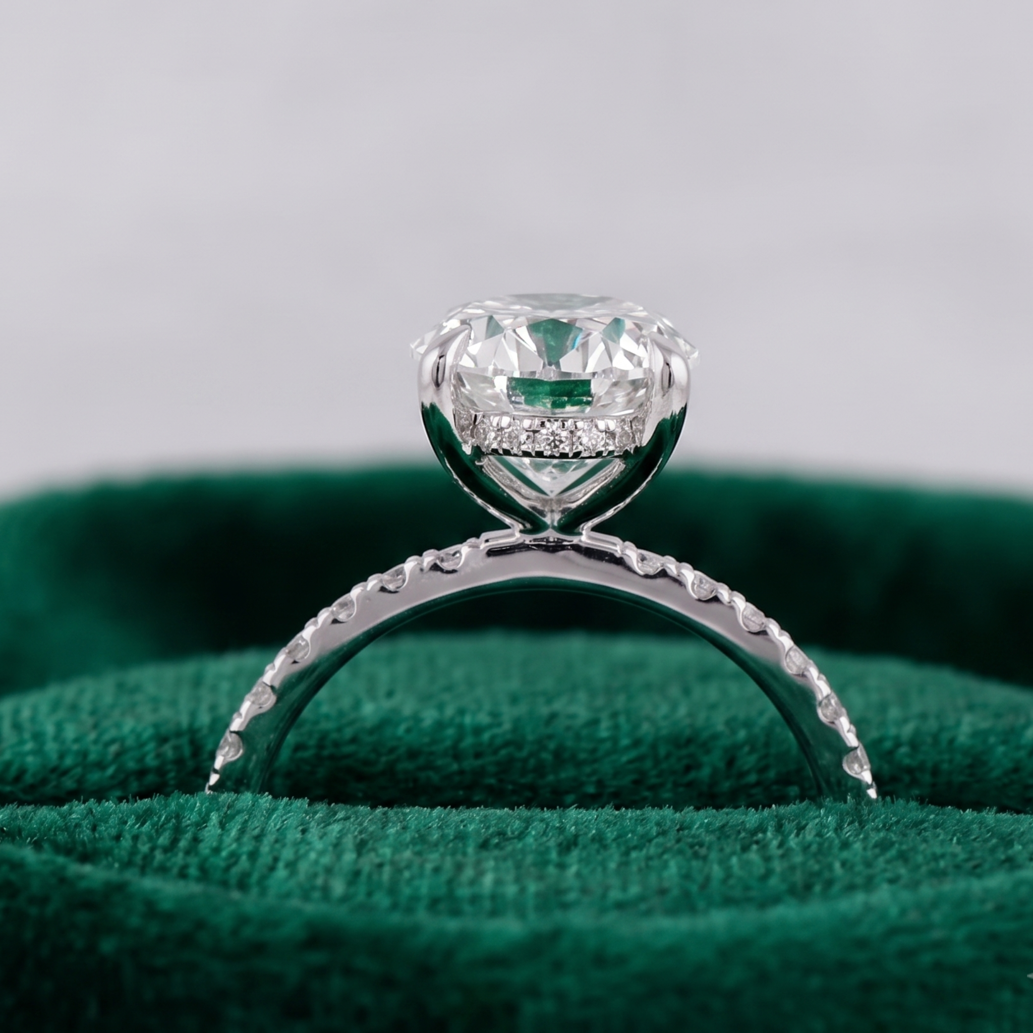 Four-prong oval diamond engagement ring with sparkling shoulders