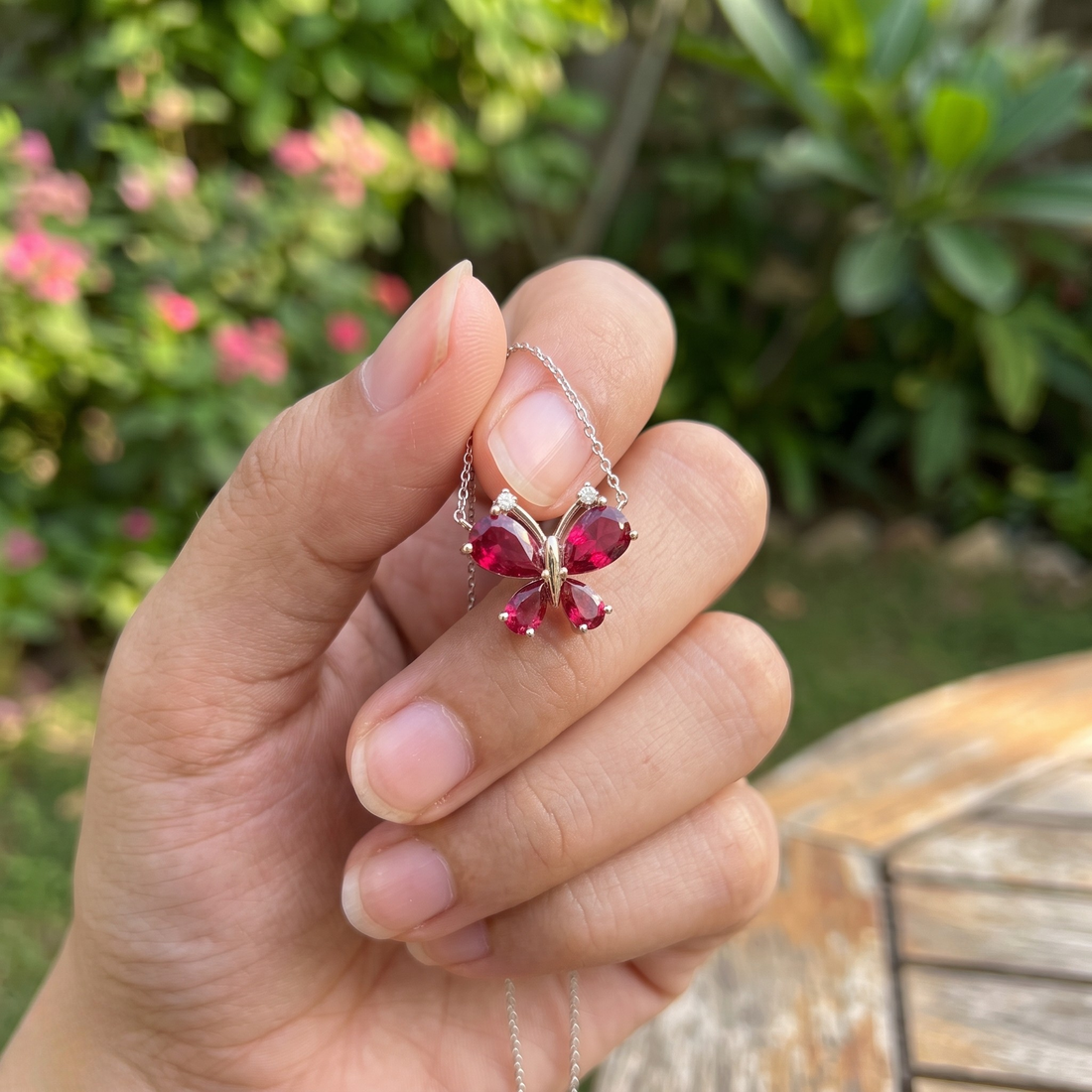 Red pear gemstone butterfly pendant necklace with lab-grown diamond accents by Kiashaa Jewellery.