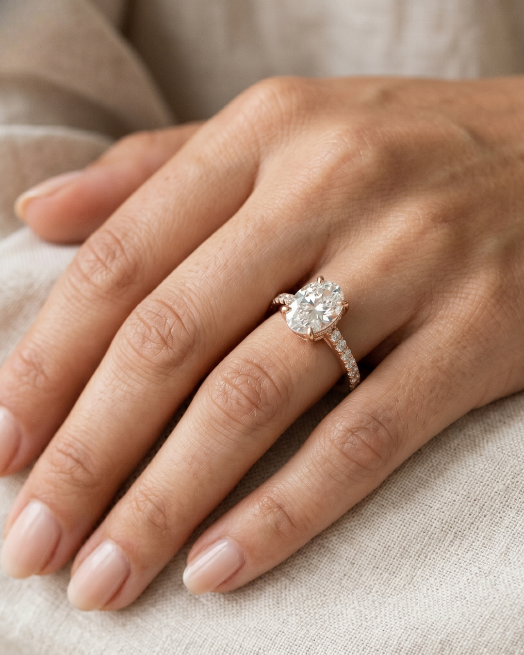 Elegant ladies oval-cut lab-grown diamond ring by Kiashaa Jewellery in rose gold with round side diamonds.