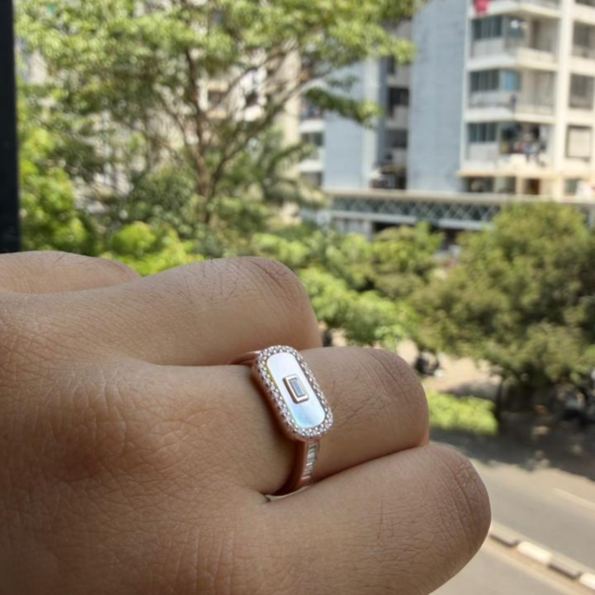 Geometric diamond ring featuring a luminous elongated mother-of-pearl center.
