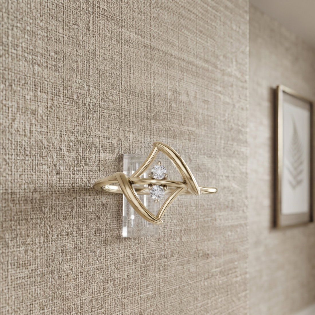 A gold-toned wall-mounted decorative light fixture with a diamond-shaped openwork frame and a small clear crystal center, shown mounted on a textured beige wall in an interior setting.
