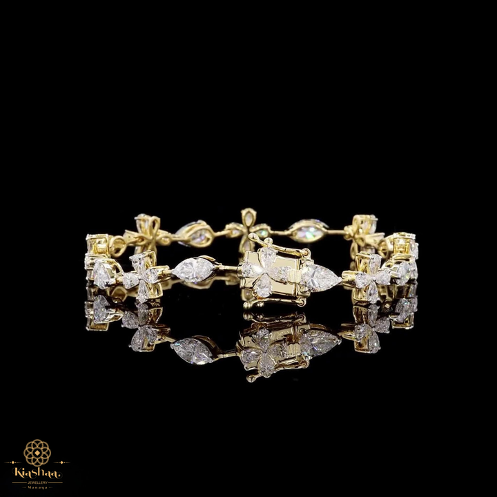 A yellow gold bracelet featuring multiple floral clusters set with clear round and marquise-cut gemstones, displayed on a reflective black surface against a solid black background.