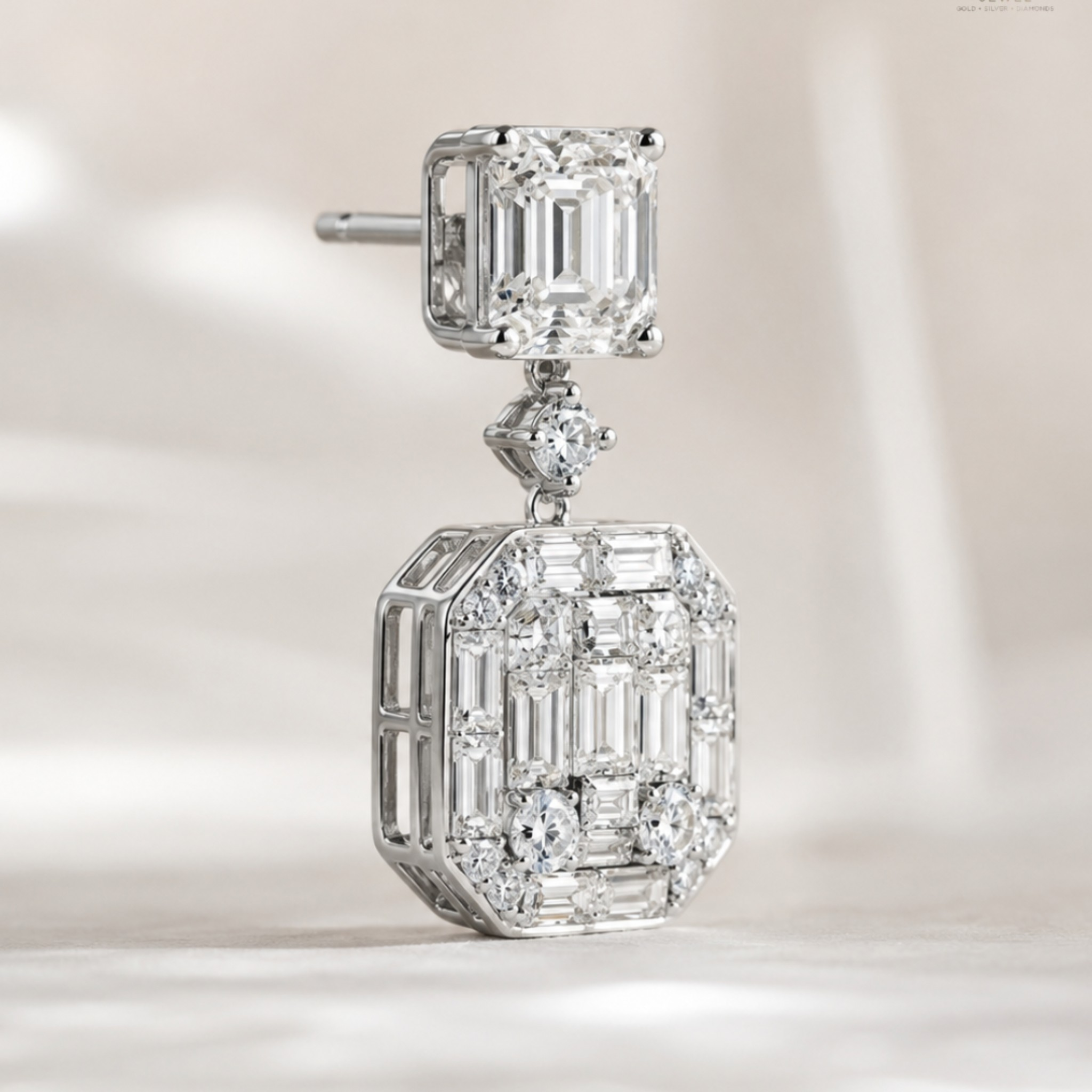 A silver-toned drop earring featuring a square emerald-cut diamond at the top and a larger rectangular baguette and round-cut diamond pavé setting below, shown on a soft light beige background.