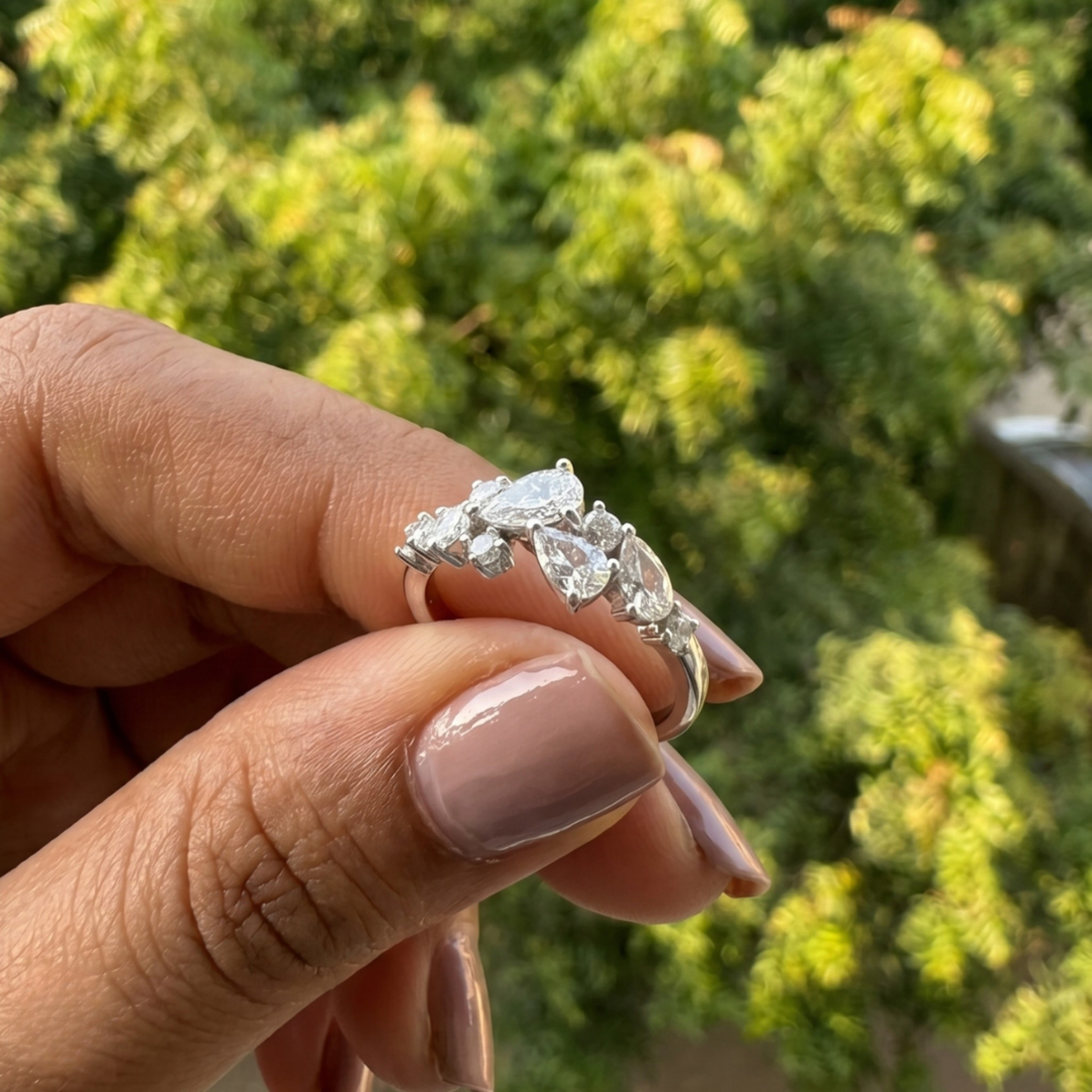Handcrafted lab-grown diamond ring with pear and round brilliant stones.