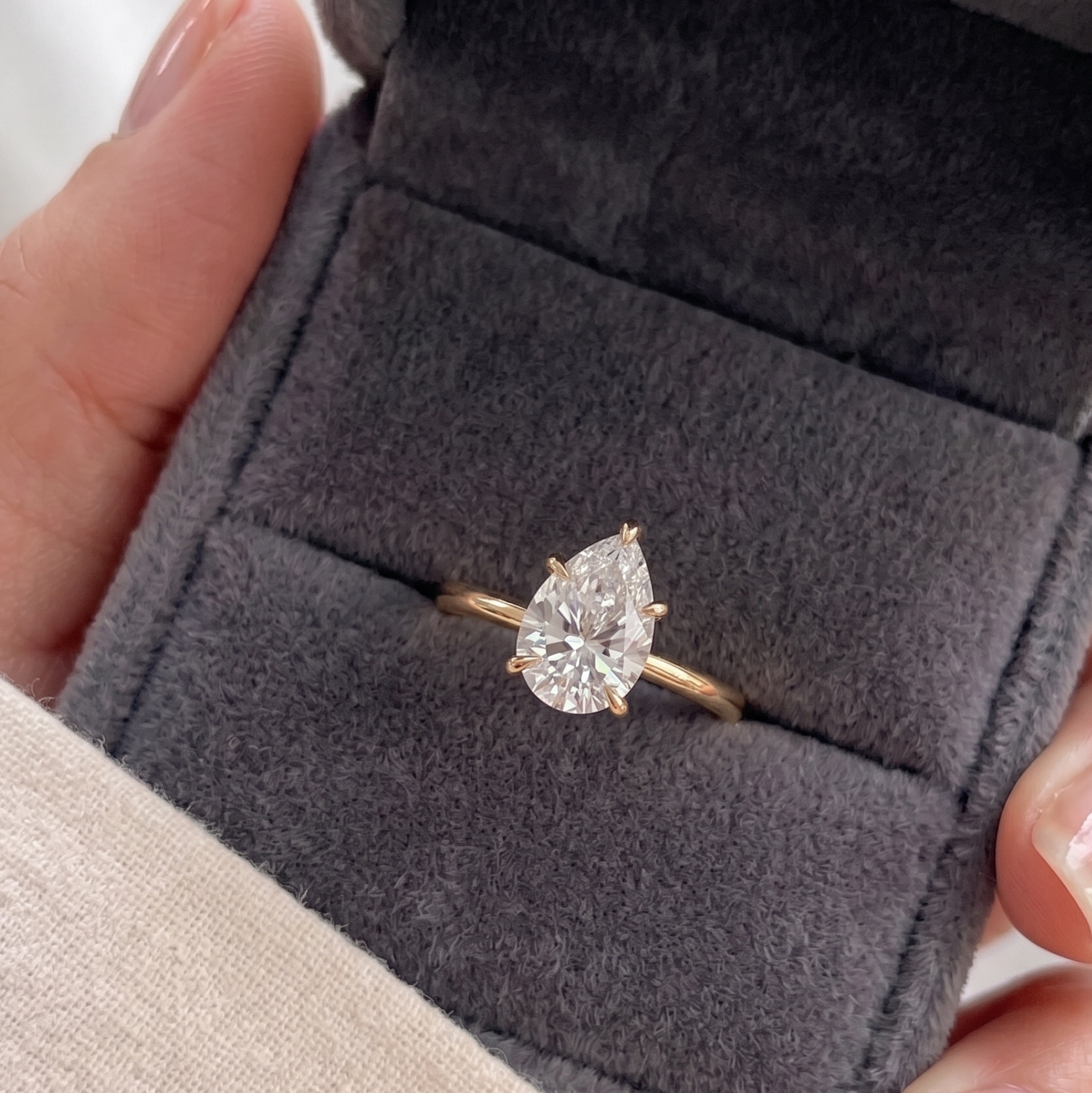 Pear-cut diamond proposal ring with slim polished gold band