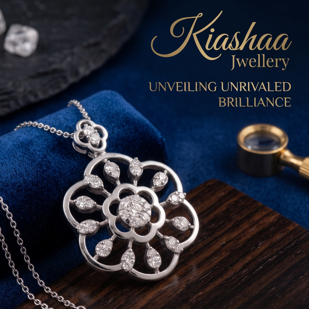 A silver-tone floral pendant necklace with clear gemstones, displayed on a dark blue velvet cushion over a wooden surface. The brand name 'Kiashaa Jewellery' is printed in gold text in the upper right, with a magnifying glass and loose stones as styled props.