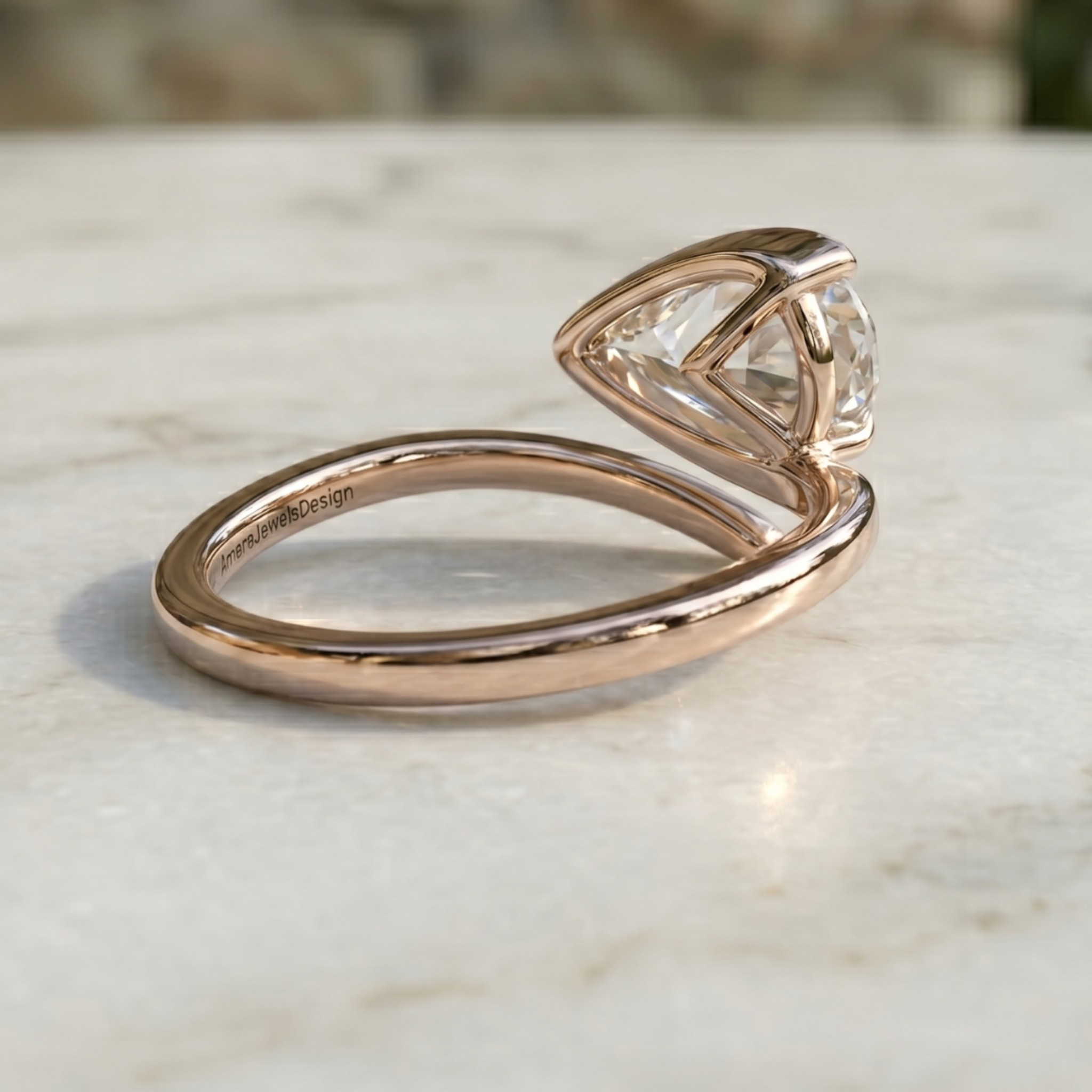 A rose gold ring with a triangular bezel-set clear gemstone, resting on a light marble surface.