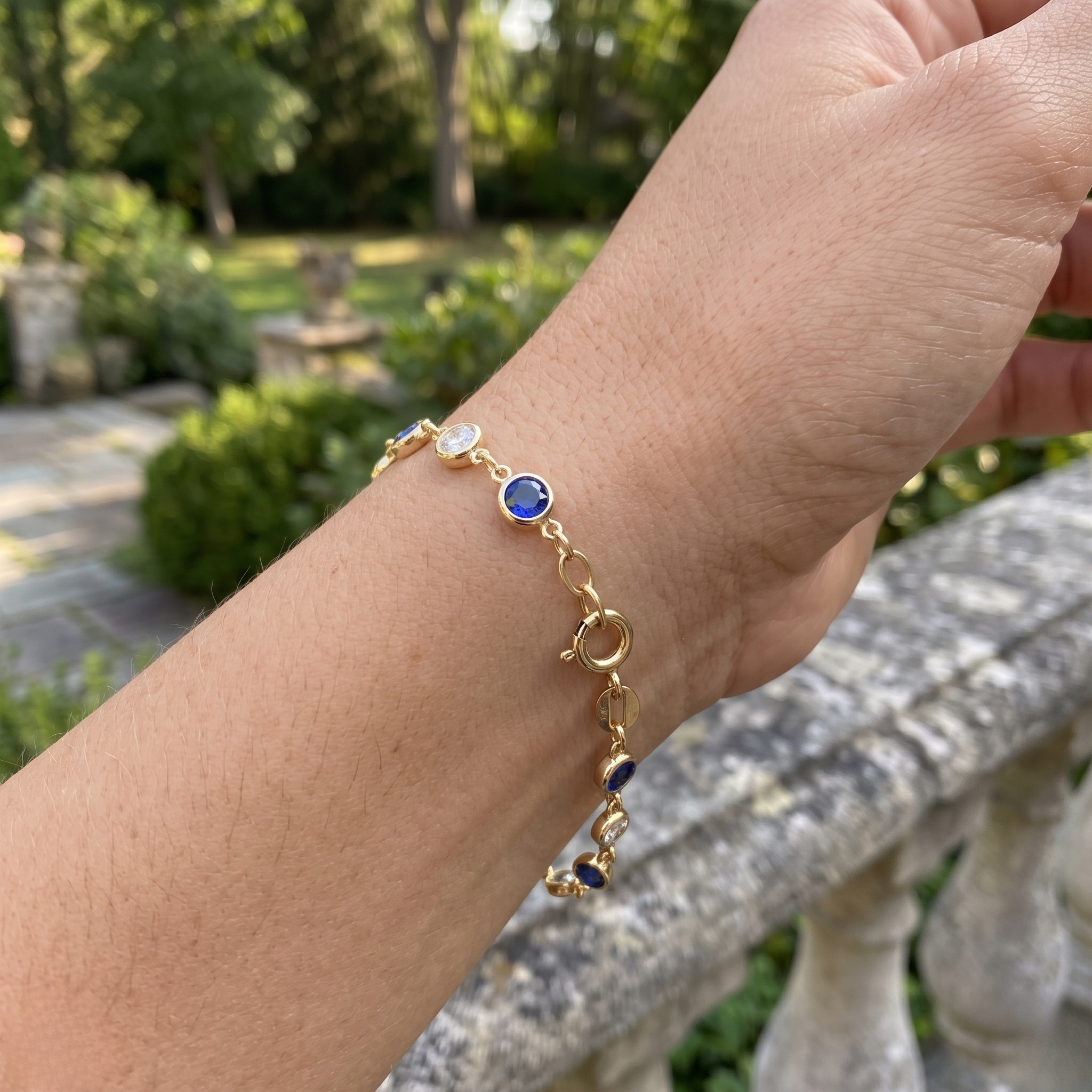Luxury tennis bracelet with round blue gemstones and brilliant white diamonds.