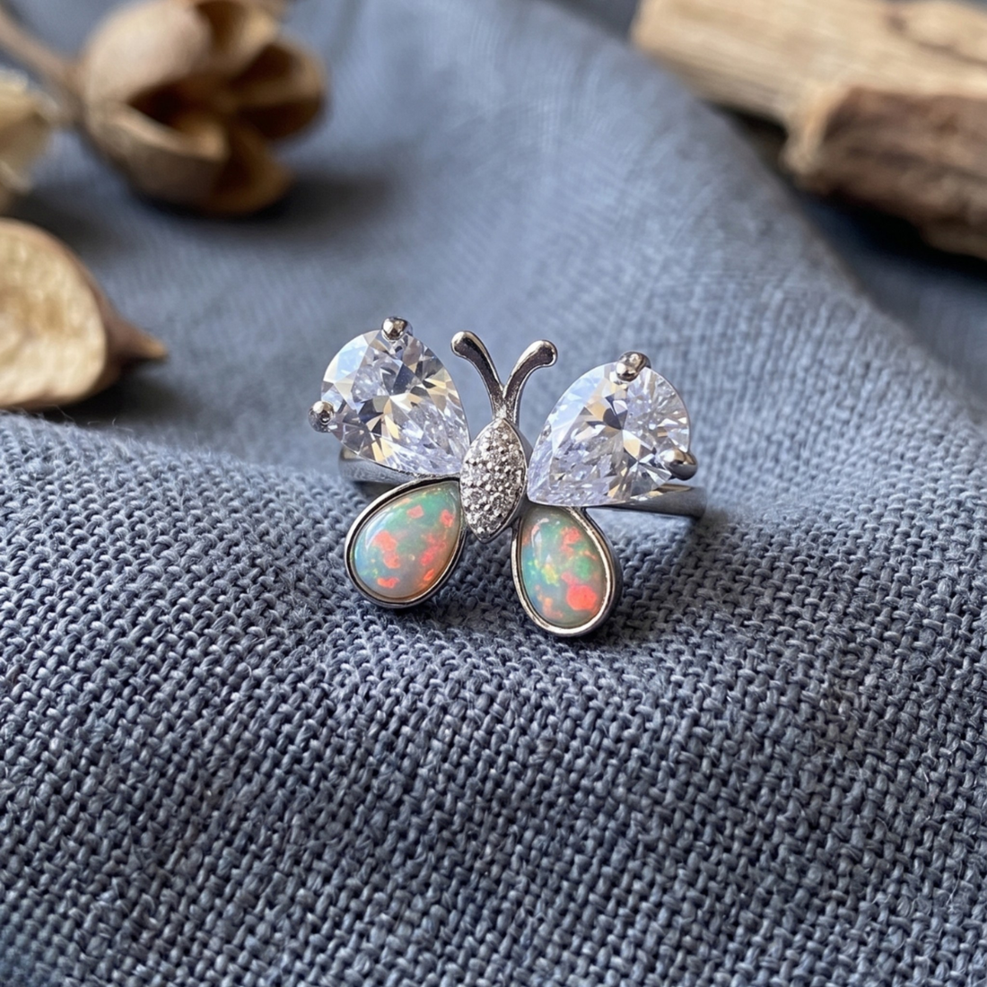 Nature-inspired butterfly ring featuring pear-shaped lab-grown diamonds and opal gemstones.
