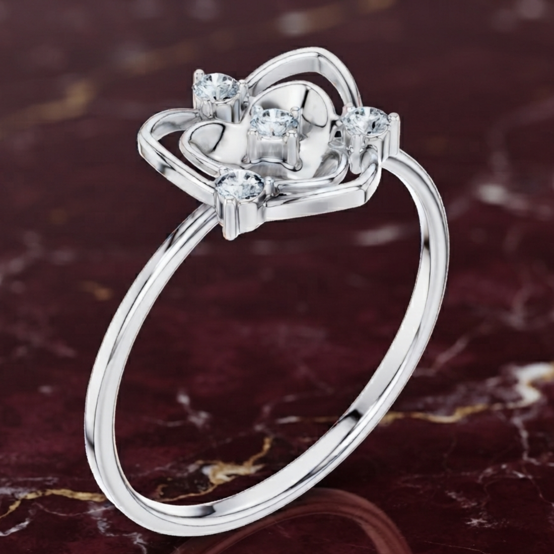 A silver-toned ring with a heart-shaped floral setting and clear gemstones, displayed on a dark marbled surface.