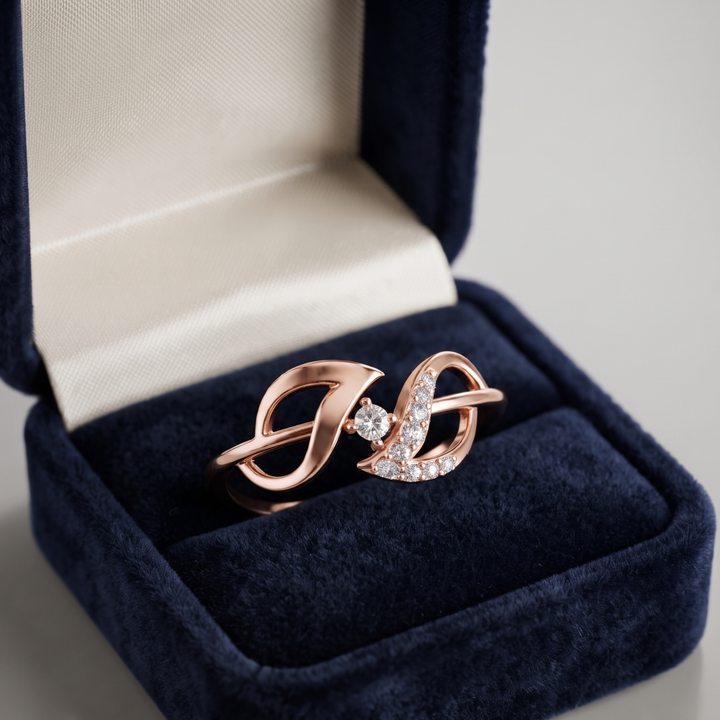 A rose gold ring with a central clear gemstone and pavé-set clear stones, displayed inside an open navy blue velvet ring box.