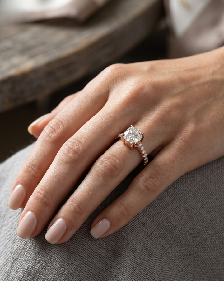 Sophisticated bridal ring with cushion-cut center stone and round side diamonds.