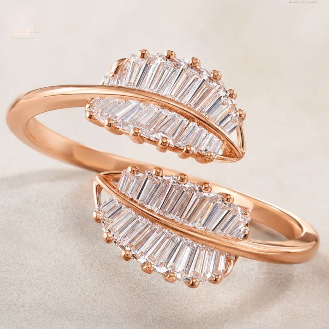 A pair of rose gold rings with curved bands and large baguette-cut clear stones, displayed on a soft neutral background.