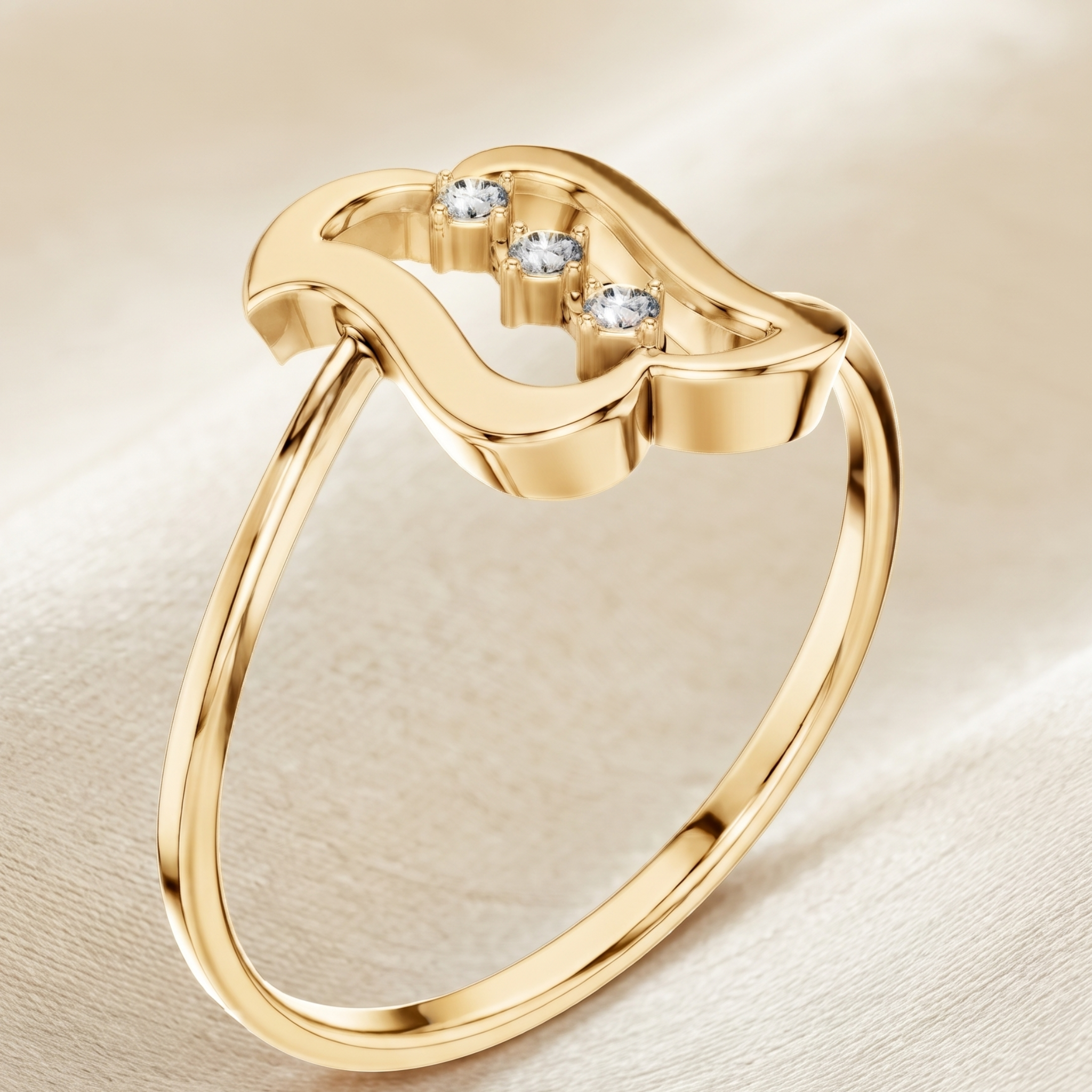 A gold ring with a wavy open top design and three small clear gemstones, photographed on a soft cream fabric background.