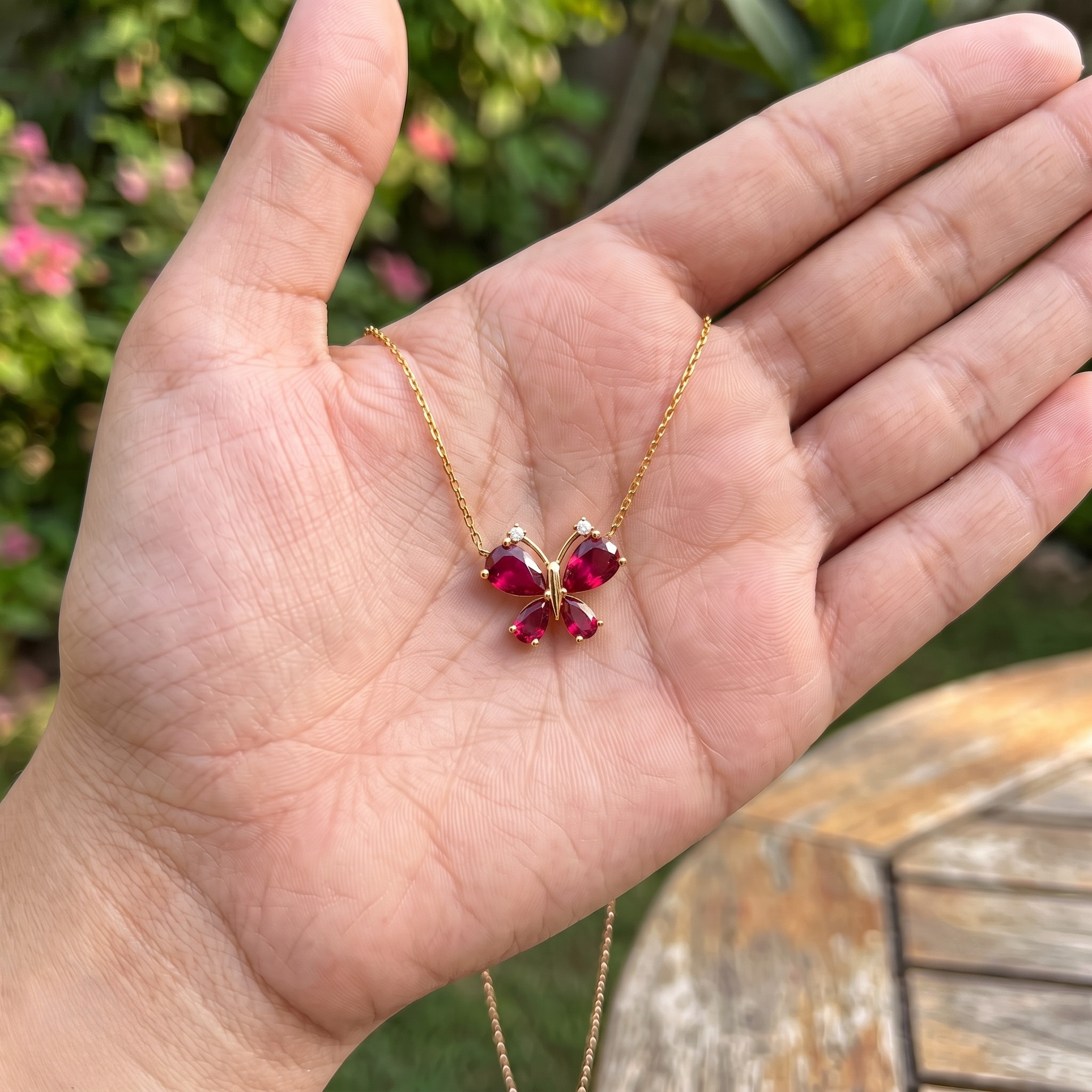 Red pear gemstone butterfly pendant necklace with lab-grown diamond accents by Kiashaa Jewellery.