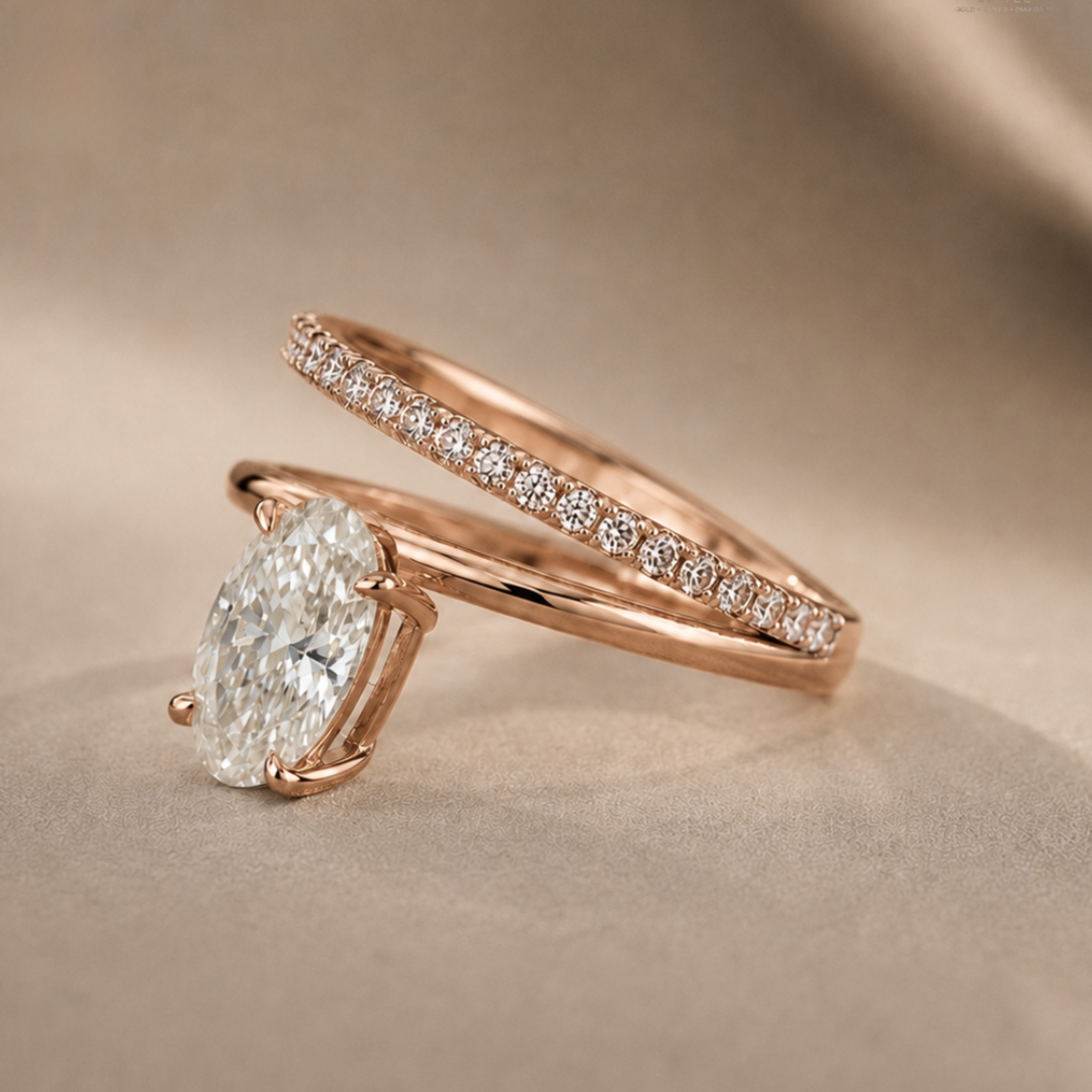 Rose gold engagement ring with a large oval-cut diamond and a matching pavé band ring, displayed on a soft beige fabric background.