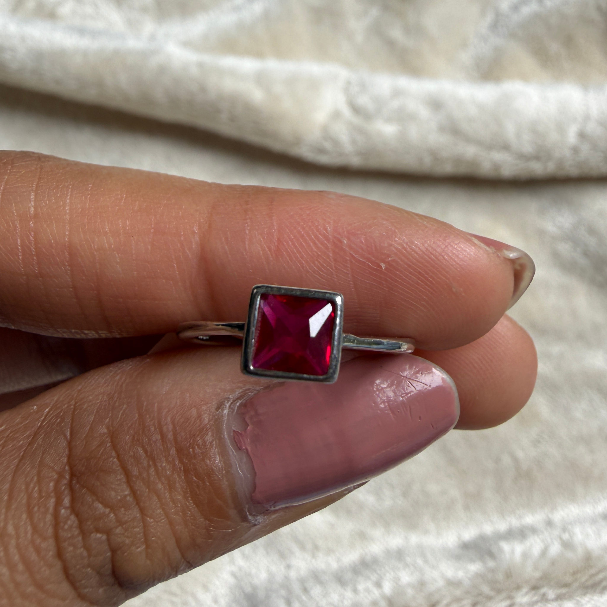 Red princess-cut gemstone solitaire ring in white gold by Kiashaa Jewellery.