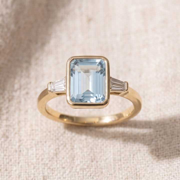 Yellow gold bezel-set blue center engagement ring