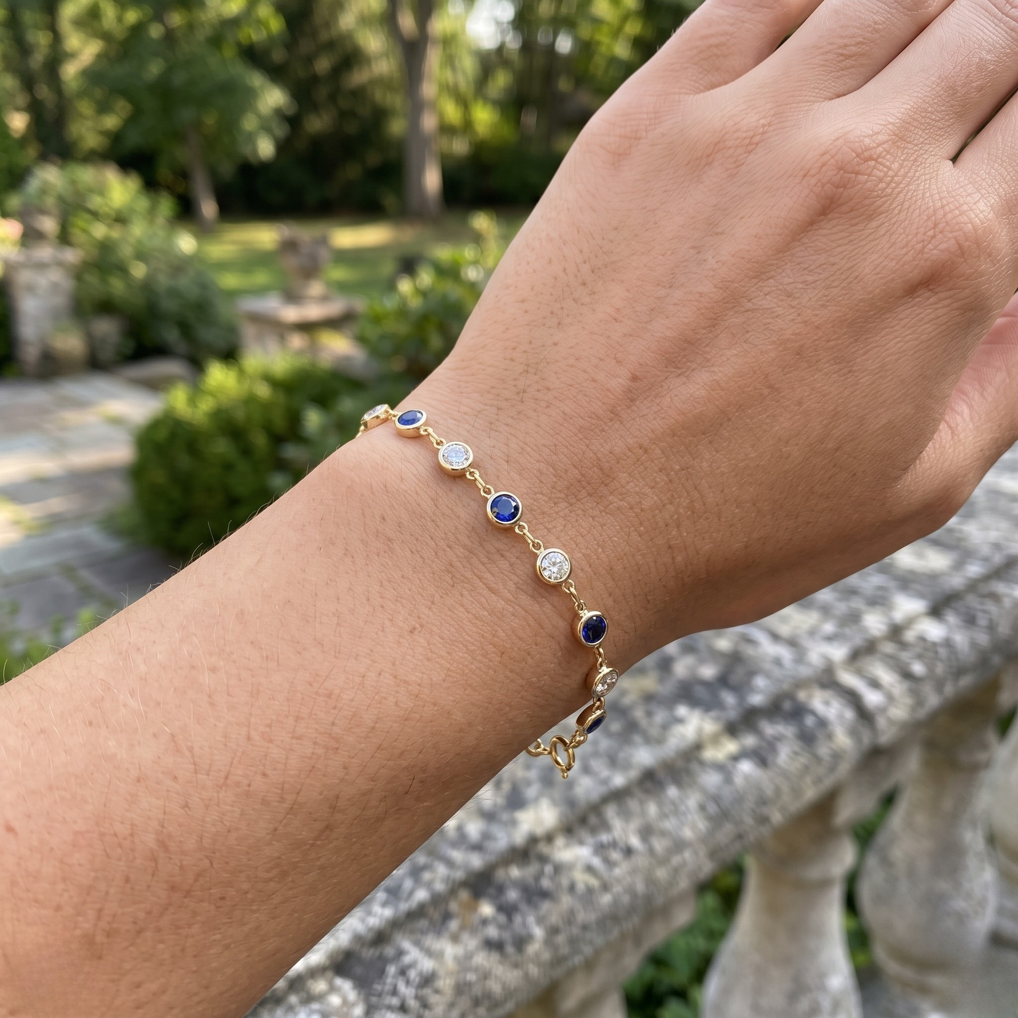 Luxury tennis bracelet with round blue gemstones and brilliant white diamonds.