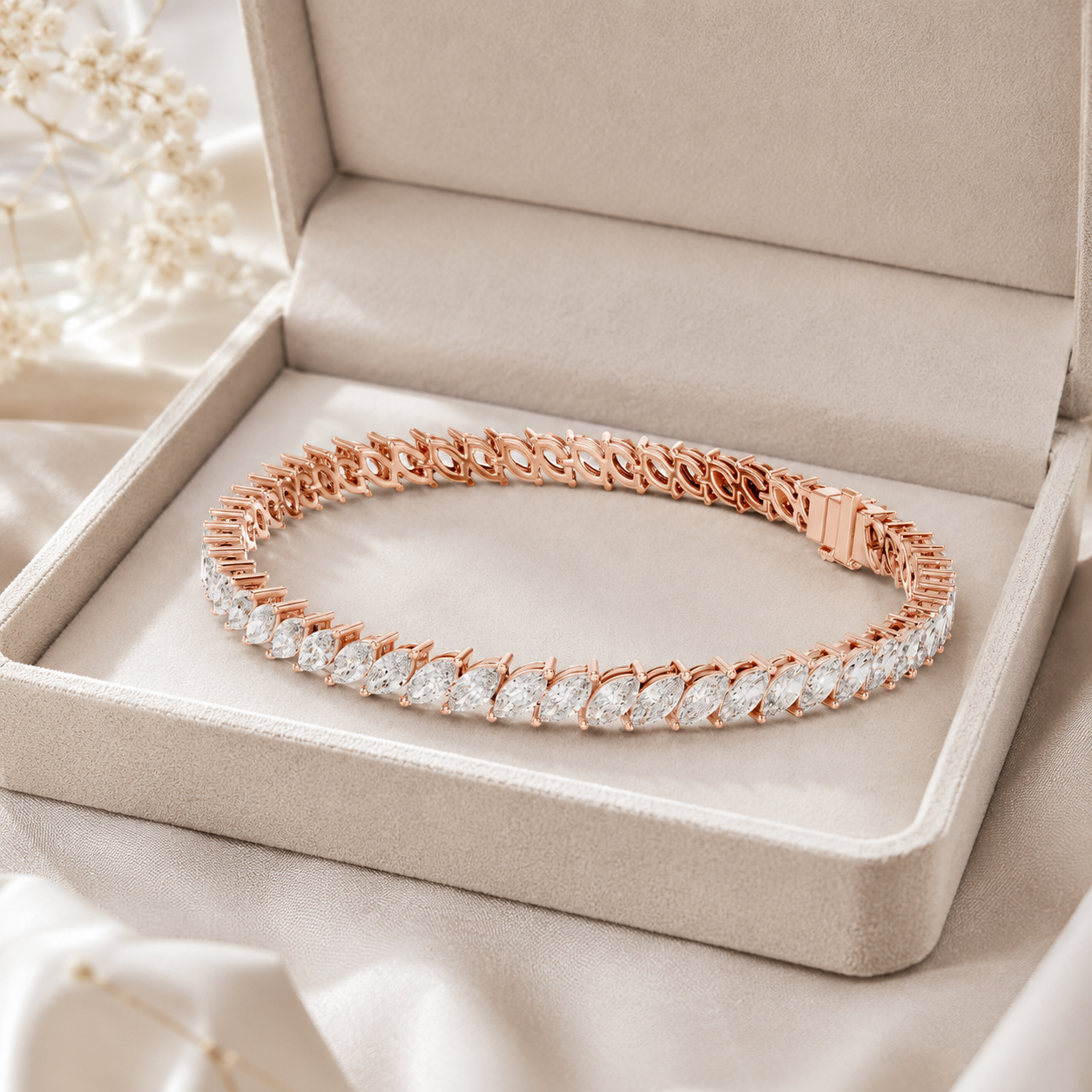 A rose gold tennis bracelet with clear stones, displayed inside an open beige jewelry box on a soft satin fabric background.