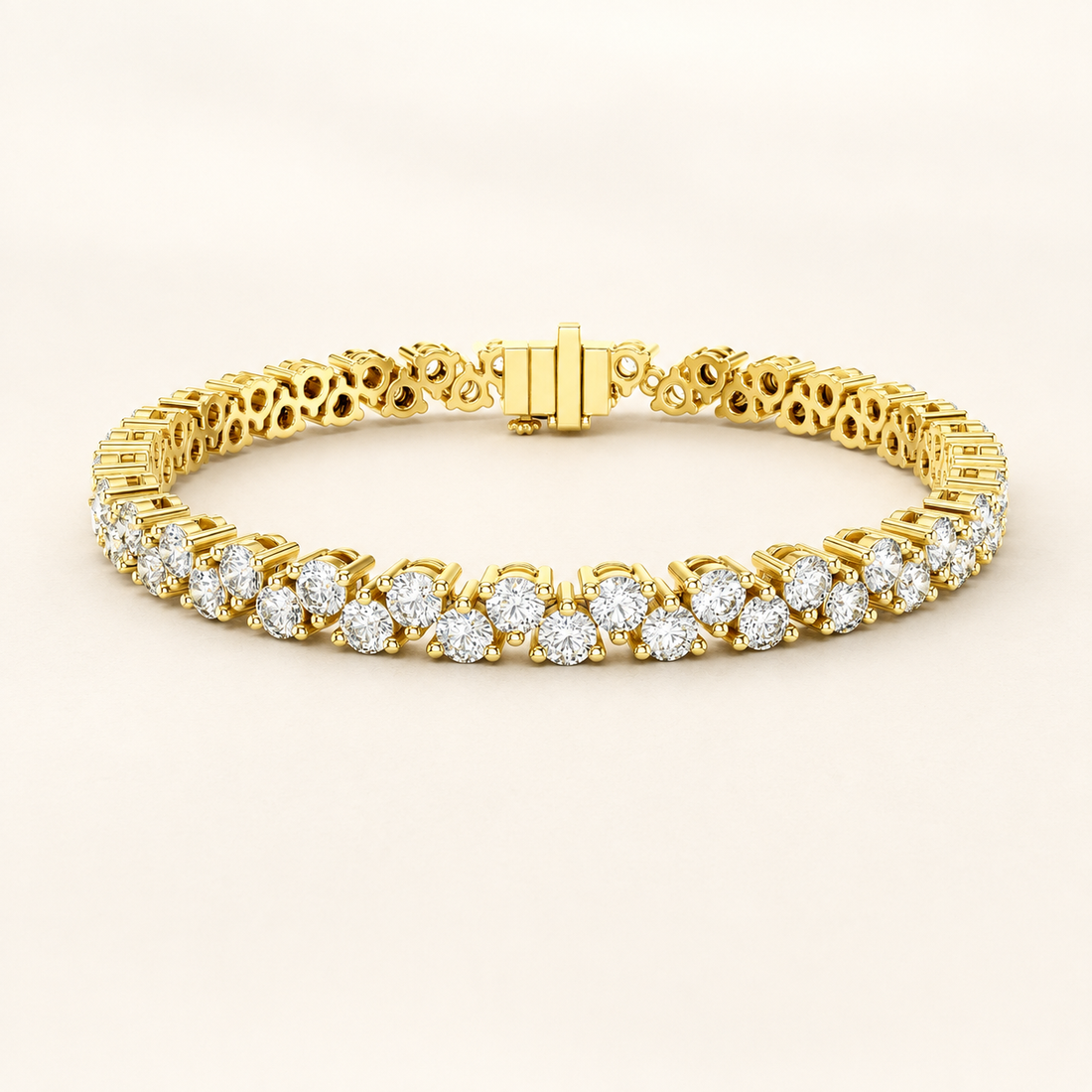 A yellow gold tennis bracelet featuring rows of round-cut clear gemstones in a classic three-stone cluster setting, displayed on a clean, light beige background.