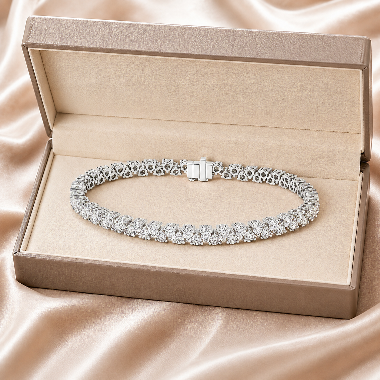 A diamond tennis bracelet displayed inside an open champagne-colored jewelry box on a satin fabric background.
