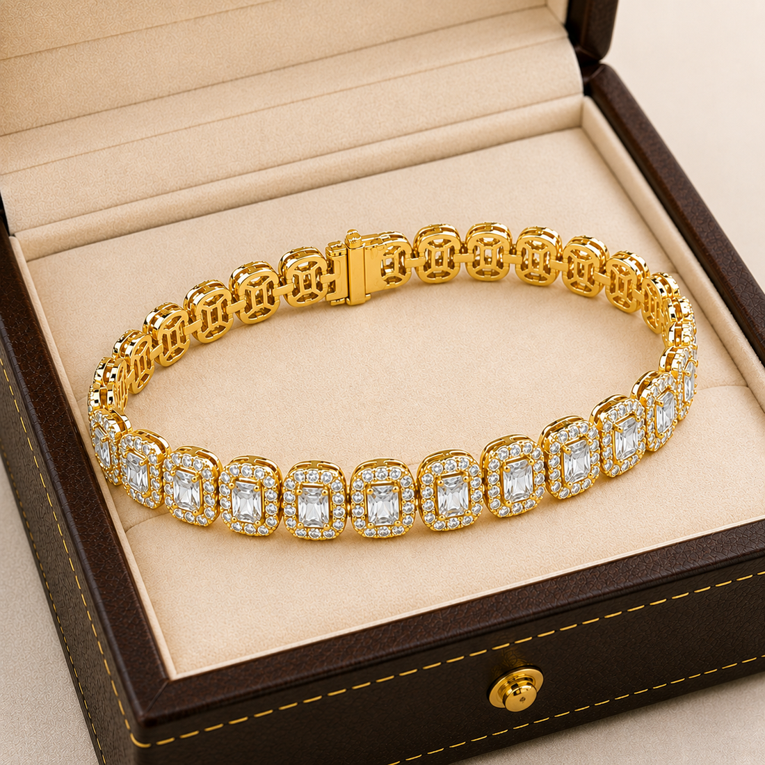 A gold tennis bracelet with rectangular clear gemstones, displayed inside an open brown jewelry box with a beige interior.